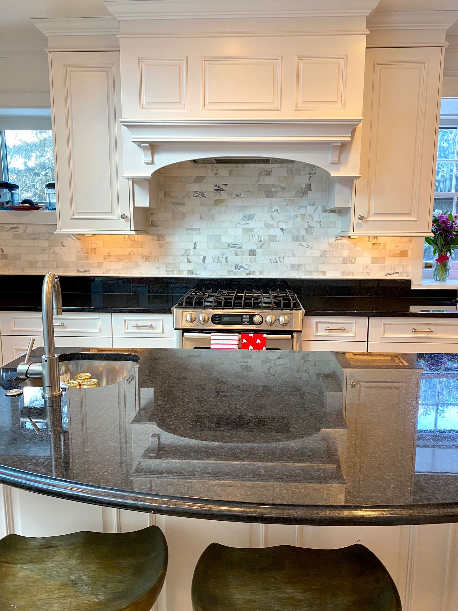 Kitchen cleaned by Dyment Cleaning Service: granite island, marble tile backsplash and gas range wiped down